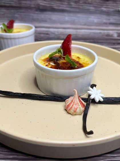 A perfectly torched Crème brûlée, a classic French dessert with a rich custard base and a contrasting layer of hard caramel.