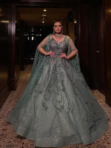 A powerful stance in our mint organza gown. The added cape gives this sparkling ball gown an extra layer of drama and sophistication, perfect for a bride who wants to feel like a queen.
