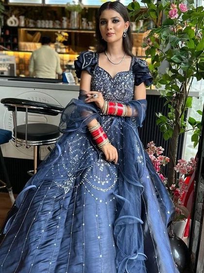 Our client posing in a cafe wearing the navy blue gown. This shows how the outfit looks in a real-world setting, perfect for an evening of celebration.
