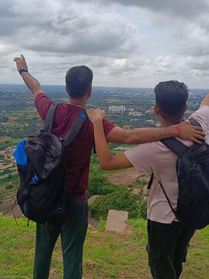 Two friends at the peak of Nijagal Betta, celebrating their climb. These treks are a great way to bond and challenge yourselves.