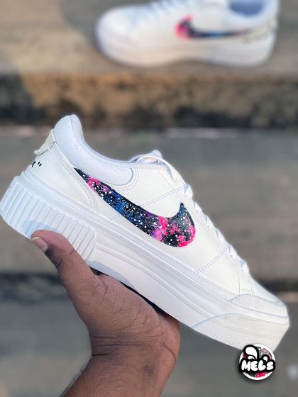 Another hand-held view of the custom galaxy Nike, highlighting the clean white platform sole.