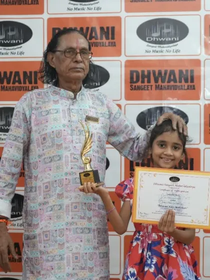 A senior guru with a young student and her award.