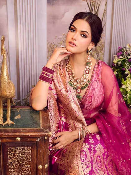 A rich, traditional look in a magenta Banarasi lehenga-saree. This is perfect for a home ceremony or pre-wedding puja, blending glamour with heritage.