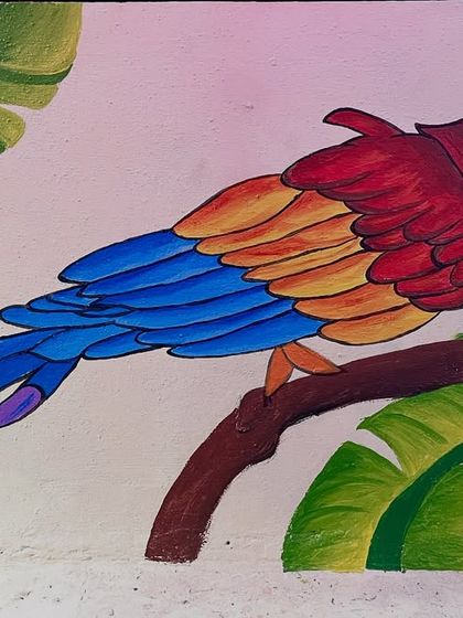 A detailed view of the macaw from the same mural, showcasing the shading on its red, orange, and blue feathers.