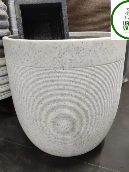 A large, U-shaped fiber pot in a light stone finish. Its simple, clean lines make the plant the hero.