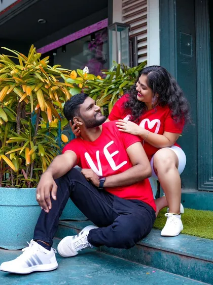 A cute and romantic pose on a doorstep. The couple's matching "LOVE" t-shirts are a sweet detail for their pre-wedding album.