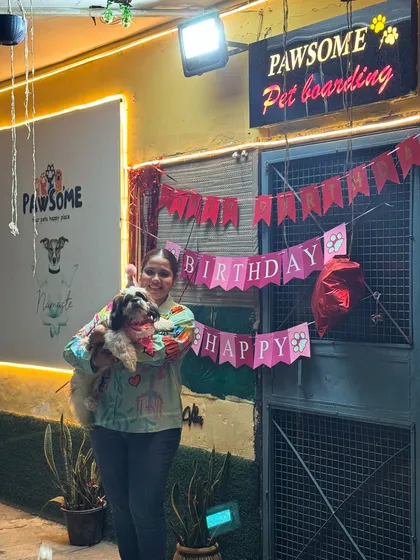 The birthday girl posing in front of her "Happy Birthday" banner. Every detail is planned to make the day special.