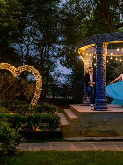 A wide shot showing the beautiful garden layout at night, with the illuminated heart and gazebo creating multiple photo opportunities.