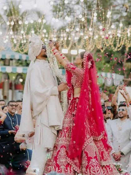 The fun and excitement of the varmala ceremony, with guests showering the couple in petals. I capture the energy of the crowd to tell the full story.