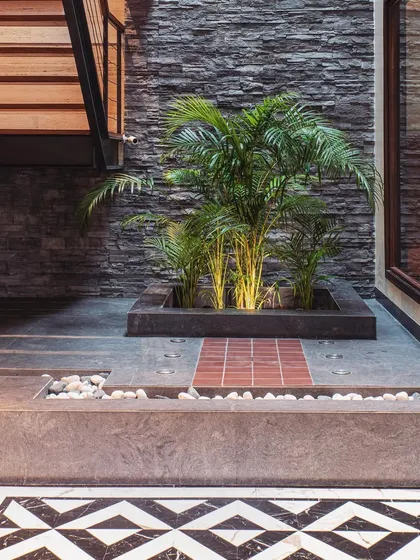I always emphasize creating key focal points. In this foyer, the Art Deco-inspired flooring pattern directs the eye towards a startlingly beautiful indoor court, complete with slate walls and tropical plants.
