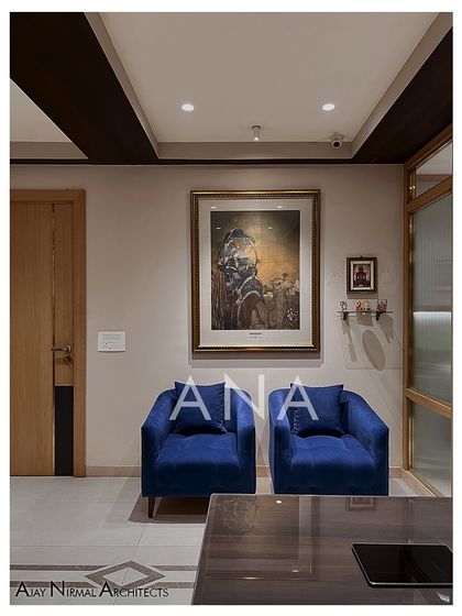 The waiting area at Jain Cosphere Office, featuring bold blue armchairs and a large piece of art. This space provides a comfortable and impressive first impression for visitors.