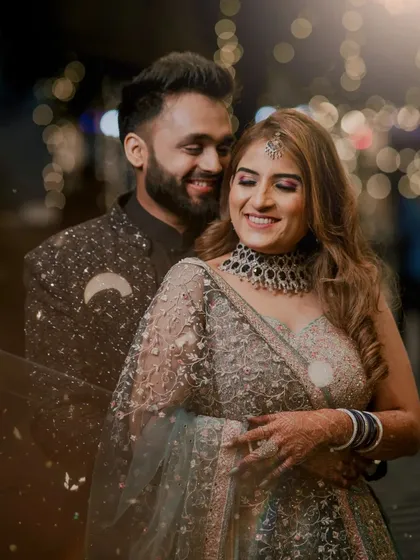 A happy and intimate portrait of the couple during their engagement party, with beautiful bokeh lights in the background.