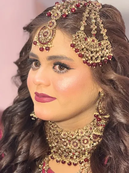 A close-up portrait of this Nikkah bride. You can see the detail in her eye makeup and how the lip color perfectly matches the tones in her jewelry and outfit.