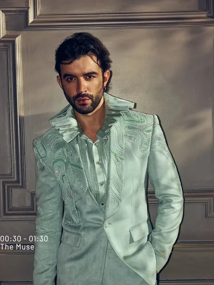 I often use color to set a tone. This suit, in a striking shade of mint, features delicate, wave-like embroidery and a unique ruffled collar. It is a piece from my summer collection, designed to be both refreshing and sophisticated.