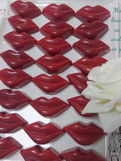 A tray of vibrant red, lip-shaped chocolates. These fun and romantic bonbons are perfect for Kiss Day or as a playful Valentine's gift.