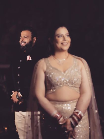 A similar candid moment from the reception, this time with both the bride and groom sharing a smile. The soft, dark background makes them stand out, creating a very romantic portrait.