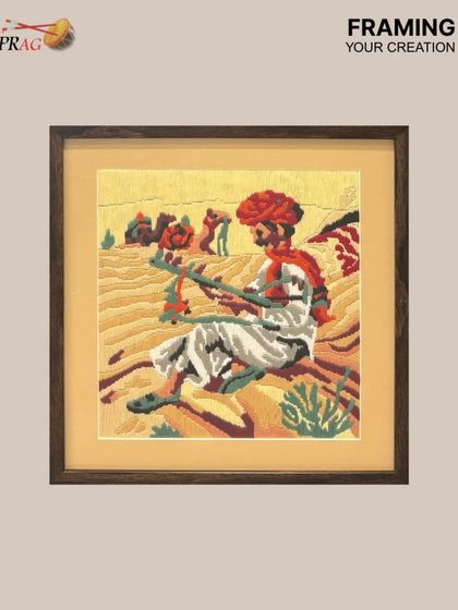 Another beautiful needlepoint creation by a client, this one depicting a Rajasthani musician. The dark wood frame provides a rich contrast to the warm desert tones of the artwork.