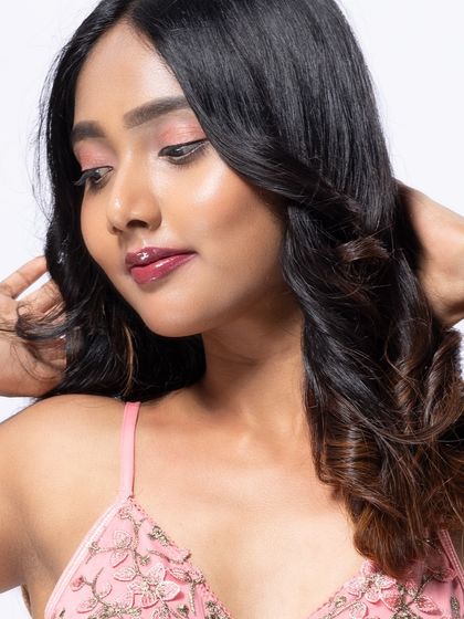 A close-up beauty shot capturing the model's soft, romantic makeup and wavy hair. The focus is on creating a gentle and pretty portrait.