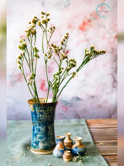 A simple, elegant vase can transform a corner of your home. This textured blue vase, paired with some fresh flowers, is a perfect example of how handmade pottery adds a touch of natural beauty.