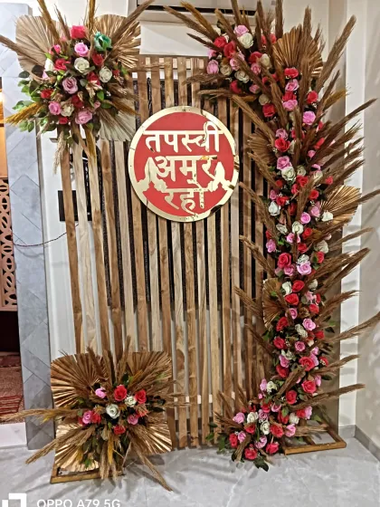 Another view of the rustic wooden backdrop for a Jain ceremony. This angle shows the beautiful arrangement of pink and white roses with pampas grass.