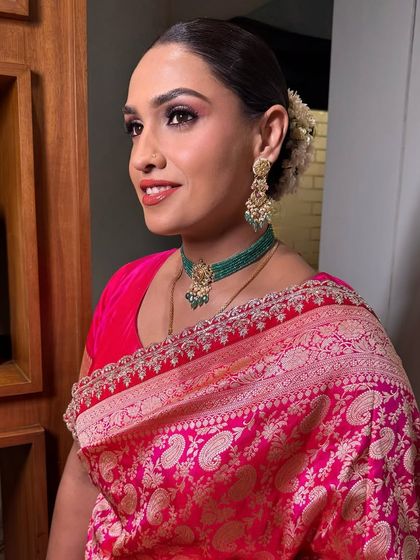 A side profile showing off the flawless skin work and the beautiful traditional gajra hairstyle.