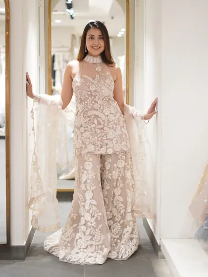 Who needs a crown when your outfit does all the talking? This all-white embroidered sharara set is the epitome of grace and elegance.