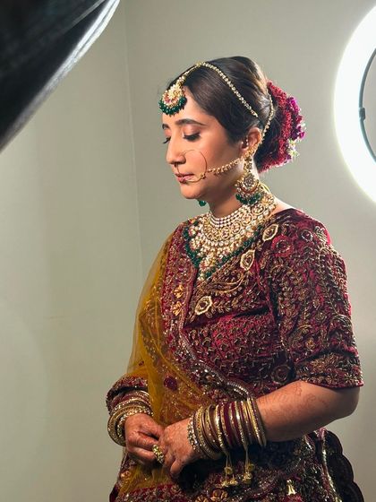 A portrait of the bride showcasing her complete look, with the floral bun adding a touch of traditional elegance.
