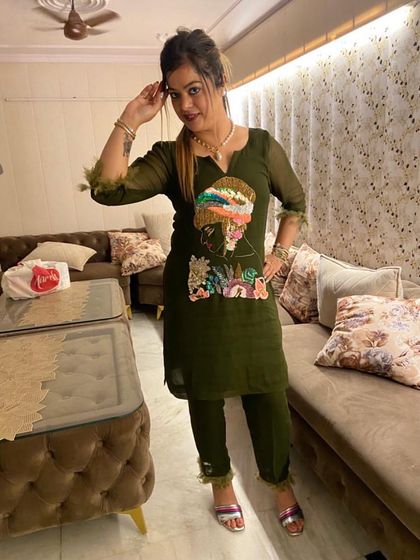 A client in a trendy olive green co-ord set with feather details and a unique embroidered patch.