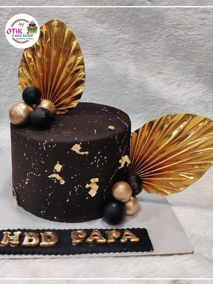A sophisticated chocolate cake for Dad's birthday. The dark chocolate, gold leaf accents, and "HBD PAPA" message make it a stylish and delicious choice.