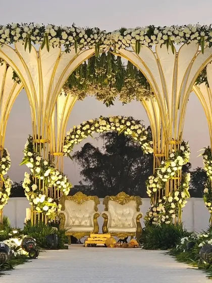 This is one of our custom mandap designs, perfect for an elegant evening wedding. The structure features beautiful arches adorned with white flowers, creating a sophisticated and romantic focal point for the ceremony.