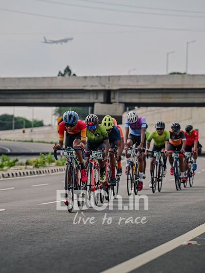The peloton, with a plane flying overhead, a unique shot from the race.