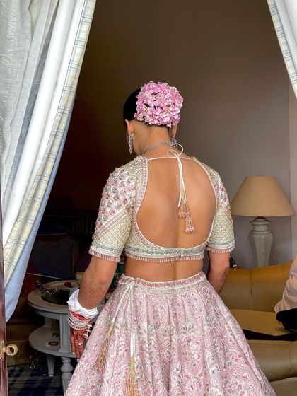 A beautiful view of a classic bridal bun adorned with a full crown of pink hydrangeas. This style is perfect for a daytime wedding, adding a touch of fresh, natural color to the overall look.