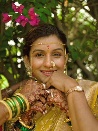 A happy bride showing off her green bangles, a traditional part of the Marathi wedding attire. Her smile is infectious.