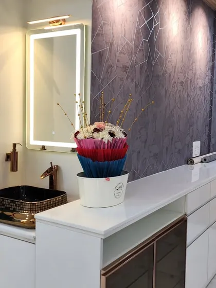 This image showcases a stylish wash basin and vanity unit integrated into the dining area, a common feature in Mumbai apartments. The backlit mirror and designer sink add a premium touch.