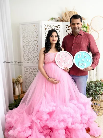 A fun gender reveal for twins! This couple holds signs for "It's a girl" and "It's a boy," celebrating the double joy they are expecting.