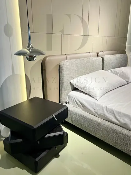 A complete bedroom set designed for a modern, serene paradise. The bed features a two-material headboard, paired with unique, sculptural black side tables and sleek pendant lighting.