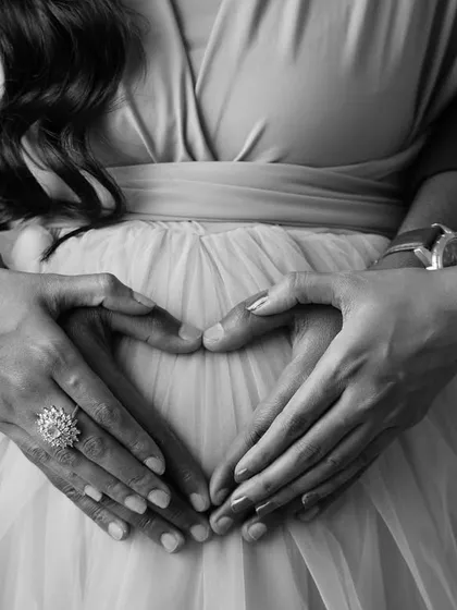 A classic for a reason, this close-up shot of parents' hands forming a heart on the baby bump is a simple yet profound symbol of love and anticipation. It’s an artistic, black and white detail shot that tells a beautiful story.