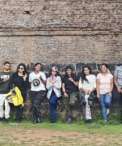 The group posing against an old fort wall during our Sakleshpura trip. Every ride is a chance to explore and discover something new.