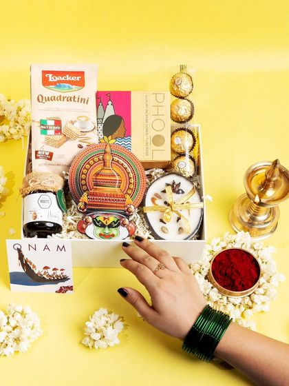 The 'Jamanthi Poo' hamper presented beautifully with jasmine flowers and a traditional lamp, capturing the complete essence of a festive Onam gift.