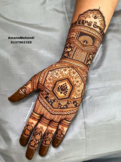 A highly intricate and dense design covering the entire hand and wrist. The central lotus motif is surrounded by geometric patterns and peacock figures, showcasing expert craftsmanship.