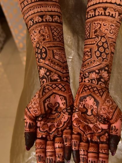 This intricate design is filled with auspicious symbols, including elephants, swastikas, and lotus flowers, all customized for the bride.