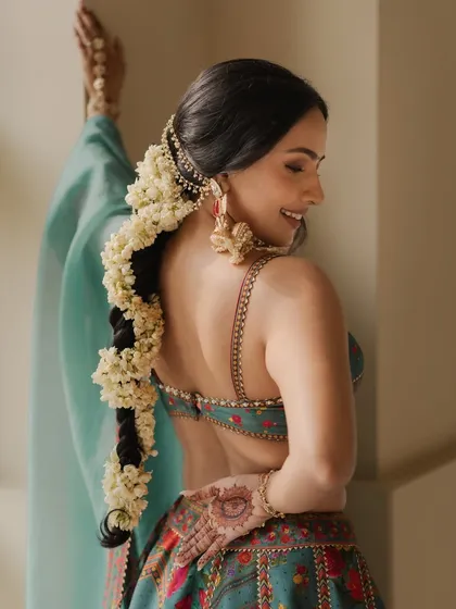 A detailed shot of Shubhangi's beautiful braided hairstyle with fresh jasmine flowers, a classic choice for a Haldi ceremony.