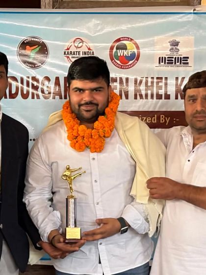 With a student and his father after a win at the Bahadurgarh Open Khel Karate Championship. Success is a team effort involving the student, coach, and family.