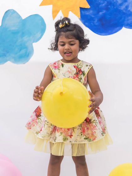 Playtime is always brighter in a fun dress. This yellow floral print dress has a tulle underskirt for a bit of extra flair, making it perfect for a party or just a day of fun.