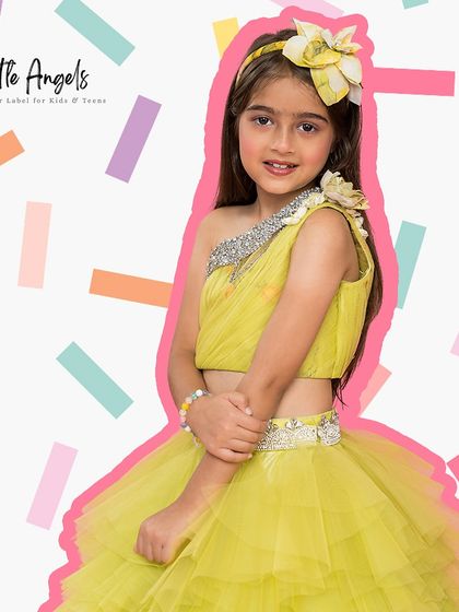 A parrot green lehenga style short dress with a one shoulder top and a tiered tulle skirt.