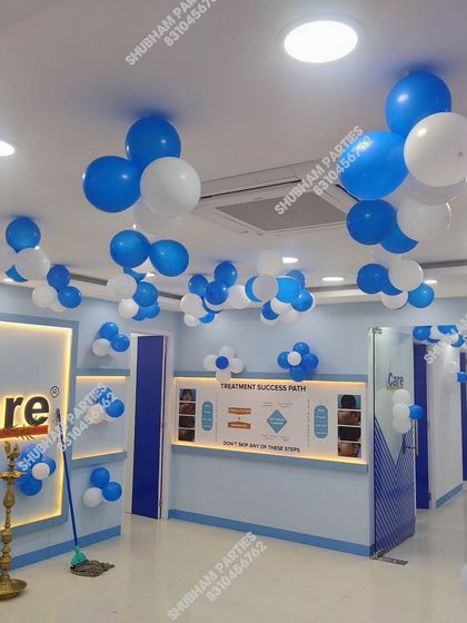A blue and white balloon decoration inside a "Care" clinic or office for an inauguration or event.
