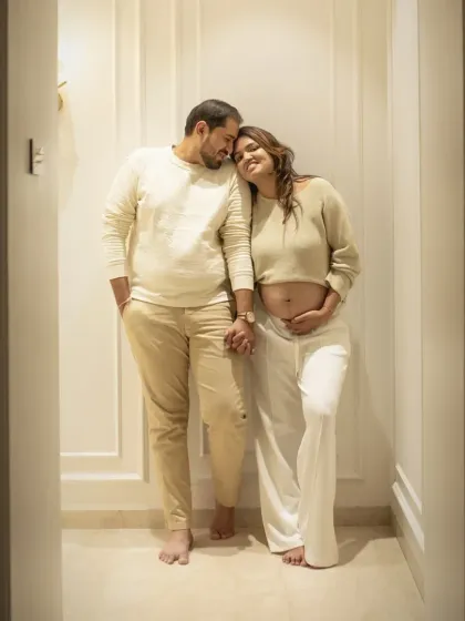 A full body portrait in a cozy home setting, capturing the couple holding hands. This shot tells a story of partnership and walking through this beautiful journey together.