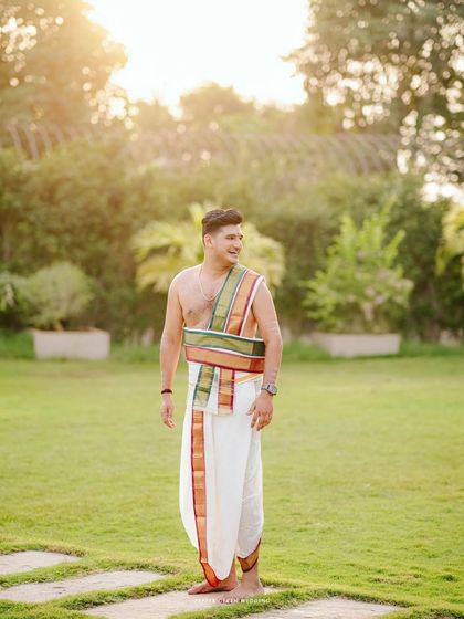 A handsome portrait of the groom in his traditional Brahmin wedding attire, captured in the golden light of the evening.