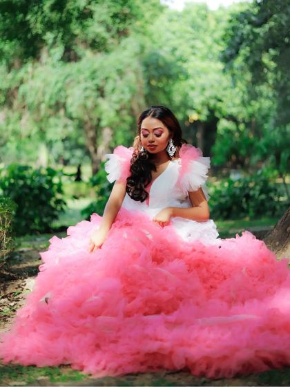 The model seated in the dramatic pink gown, with makeup that enhances her features without overpowering the elaborate outfit. A perfect balance for conceptual fashion photography.