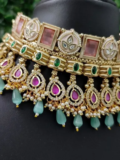 A unique choker set with a beautiful combination of pastel pink, green, and mint-colored stones. This is a very fresh and modern rental piece.